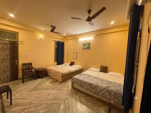 a hotel room with two beds and a ceiling fan at Annapurna Homestays in Varanasi