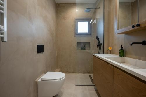 a bathroom with a toilet and a sink at Trigono Suites - Primavera 
