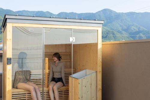 a woman is sitting in a tiny house at ENINARU East in Otsu