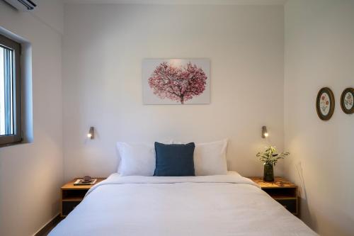a bedroom with a large white bed and two tables at Trigono Suites - Primavera 
