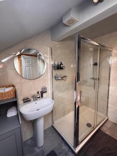 a bathroom with a shower and a sink and a mirror at The Cloud in Alderley Edge