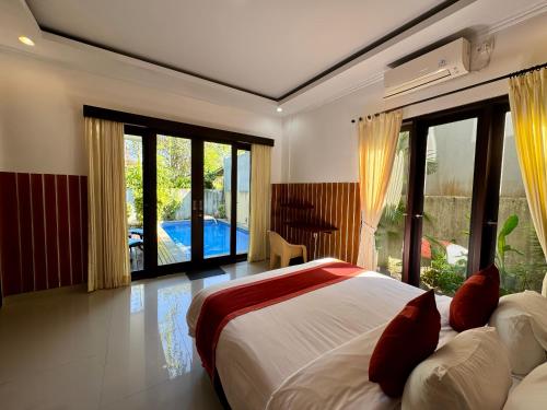 a bedroom with a bed and a large window at Ramantika Sunset Bay in Nusa Dua