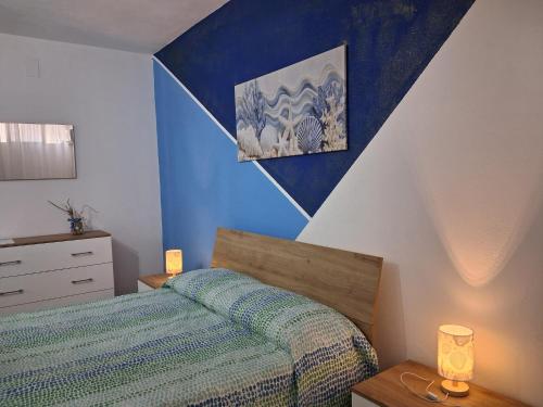 a bedroom with a bed and a blue and white wall at Appartamento Tavernetta Corallo Rosso in Isca Marina