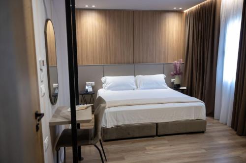 a bedroom with a bed and a table and a mirror at KAÑ Inn in Vlorë