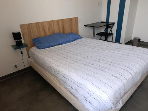 a bedroom with a large bed with a wooden headboard at La Halte in Torigni-sur-Vire