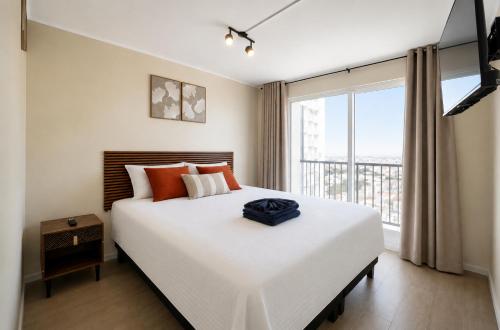 a bedroom with a large bed and a large window at Suite moderna espacio parque in Calama