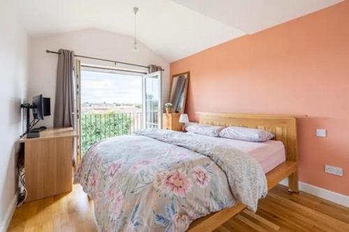 a bedroom with a large bed and a window at Bright Double Room with Shared Bathroom in Luton