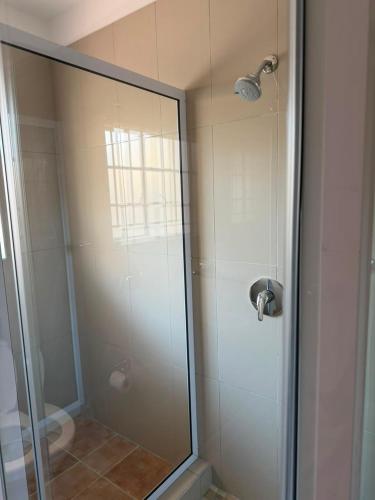 a bathroom with a shower with a glass door at Essie's Place in Windhoek