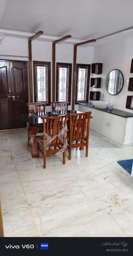 a dining room with wooden chairs and a table at Graps Ocean Stay in Chīrāla