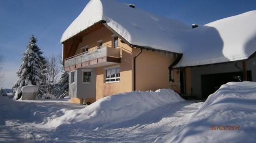 ein schneebedecktes Haus mit einem Schneehaufen in der Unterkunft Haus Grabenbühl in Wieden