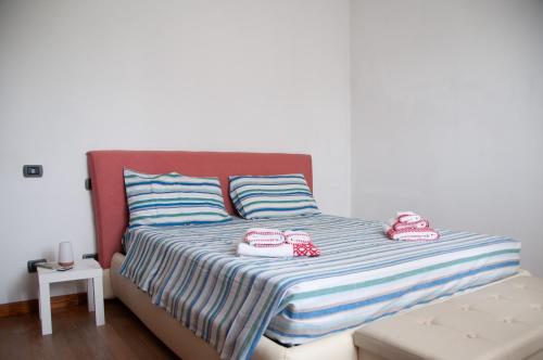a bed with two towels and two shoes on it at Three Tails House in Capezzano Pianore,