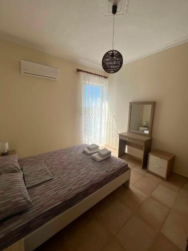 a bedroom with a bed and a dresser and a mirror at Karfas Seascape in Chios