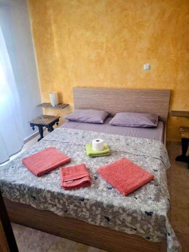 a bedroom with a bed with red towels on it at Lionz Village in Skala Fourkas