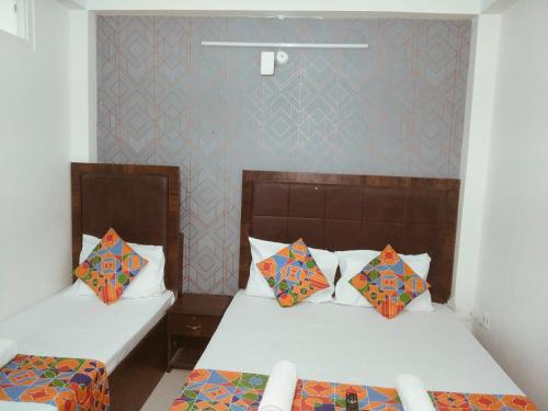 two beds in a small room with two beds sidx sidx sidx at Hotel Tirumala Vaibhav in Secunderabad