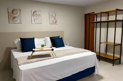 a bedroom with a large white bed with blue pillows at Compact Studios Close to Shopping Centers, Downtown, Arena, Airport in Manaus