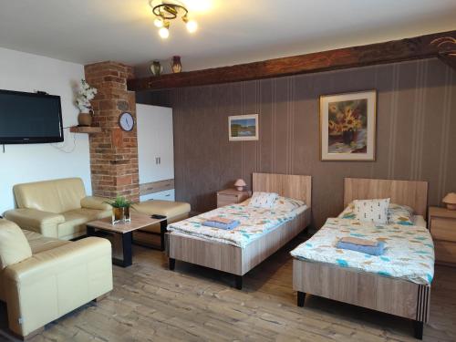 a living room with two beds and a couch at penzion U Hájků in Křepice