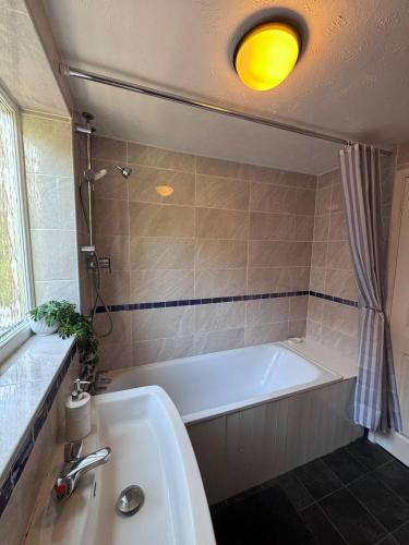 a bathroom with a white tub and a sink at Central Stay in Southampton