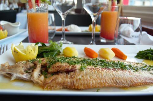a plate of food with a fish on a table at Hotel La Terrasse in Fort-Mahon-Plage