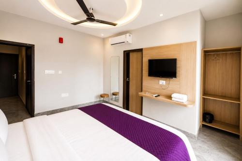 a bedroom with a large bed and a flat screen tv at Hotel Elev11 Near Ambala Chandigarh Highway, Zirakpur in Zirakpur