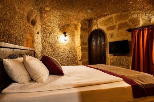 a bedroom with a bed in a stone wall at la mar cave cappadocia in Ürgüp