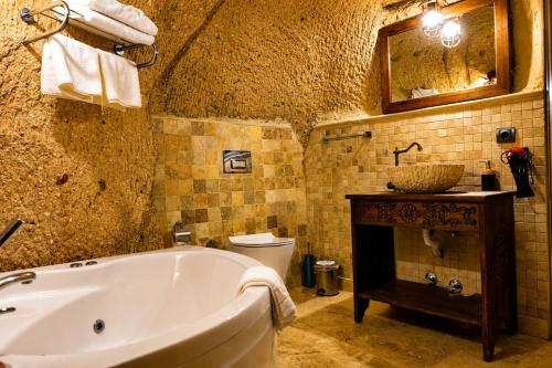 a bathroom with a tub and a toilet and a sink at la mar cave cappadocia in Ürgüp