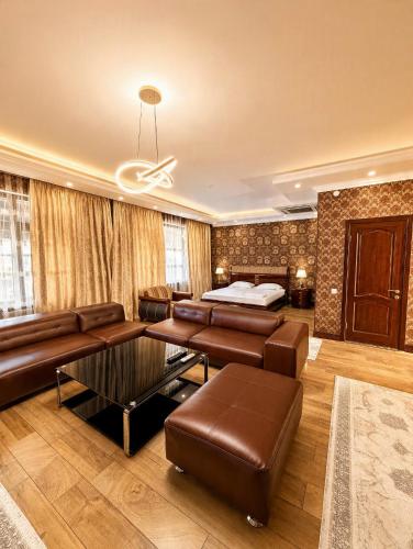 a living room with a couch and a bed at Seoul Hotel in Shymkent