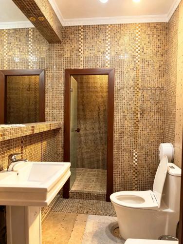 a bathroom with a toilet and a sink and a shower at Seoul Hotel in Shymkent