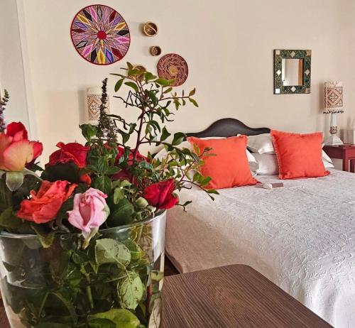 a bedroom with a bed with a vase filled with roses at Ithaki House in Lyso