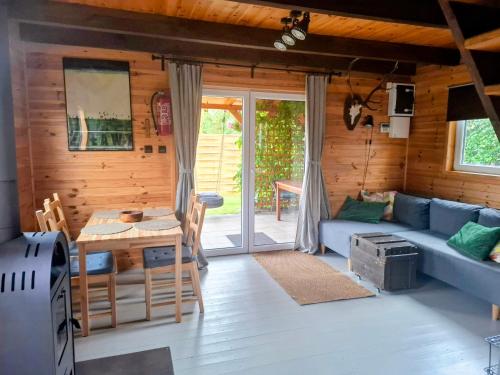 a living room with a blue couch and a table at Śledziowy Domek 