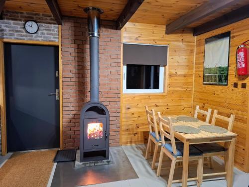 a wood stove in a room with a table at Śledziowy Domek 