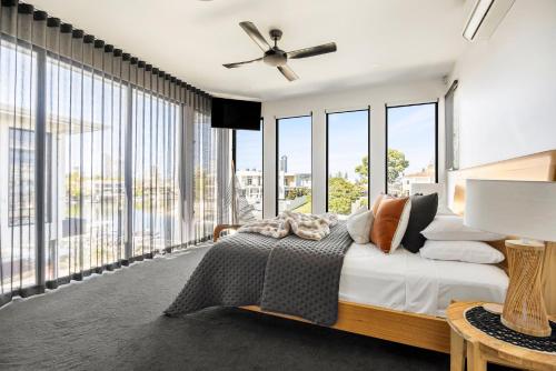 a bedroom with a bed and large windows at Bluewater Oasis - Stay 4 Pay 3 in Gold Coast