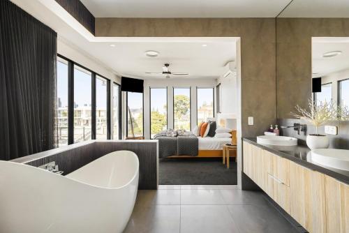 a bathroom with a tub and a bedroom with a bed at Bluewater Oasis - Stay 4 Pay 3 in Gold Coast