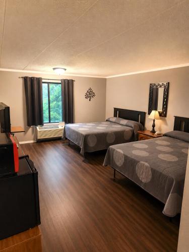 a hotel room with two beds and a flat screen tv at Chateau Royale Inn in Lake Geneva