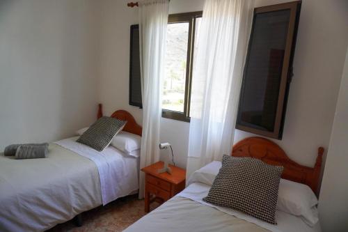 a bedroom with two beds and a window at Casa Argelio in Alojera