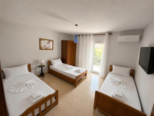a room with two beds and a television in it at Eiffel's Guest House in Pogradec