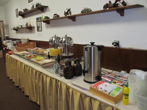 a table in a room with a counter with food at Penzion Alpský Dům in Železná Ruda