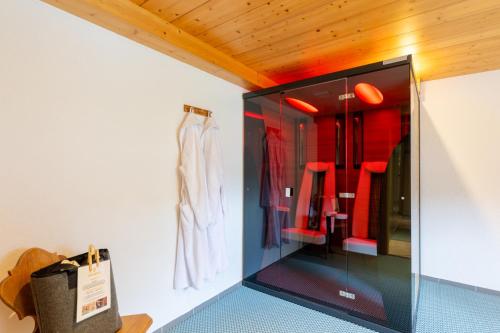 a glass display case in a room with red clothes at Hotel Elisabeth in Schoppernau
