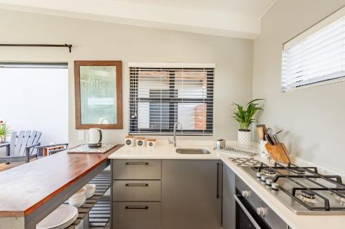 a kitchen with a sink and a stove at Chapmans Corner Studio in Noordhoek