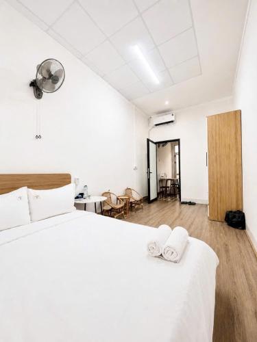 a bedroom with a white bed and a table and chairs at 44 đặng dung in Buon Ma Thuot