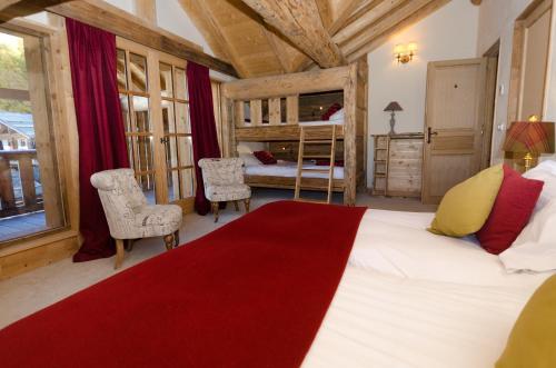 a bedroom with a large bed with a red blanket at Black Diamond Sainte Foy Chalets in Sainte-Foy-Tarentaise