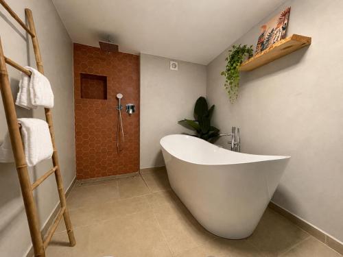 a bathroom with a white tub and a shower at Calheta Suites - Vinha & Jardim - Adults-only suites met hottub & zeezicht in Calheta