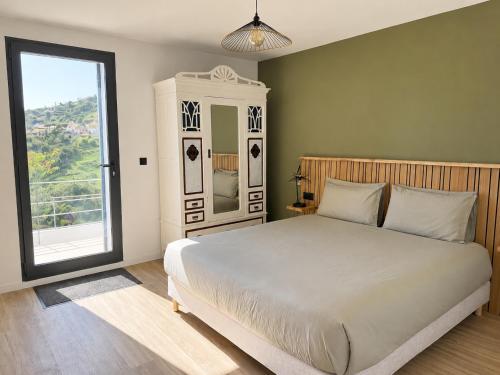 a bedroom with a large bed and a large window at Calheta Suites - Vinha & Jardim - Adults-only suites met hottub & zeezicht in Calheta