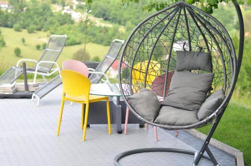 a swing with chairs and a table on a patio at Villa Saraj with Swimming Pool & Jacuzzi near Sarajevo in Sarajevo