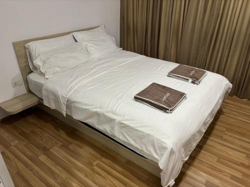 a bed with white sheets and a brown tray on it at Sukhumvit​ 101 in Phra Khanong
