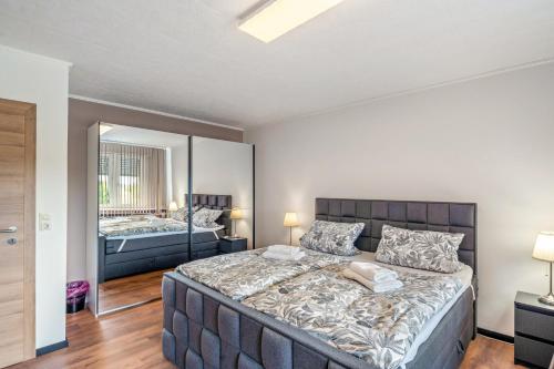 a bedroom with a large bed and a mirror at Land Leben Wohnung 1 in Erkelenz