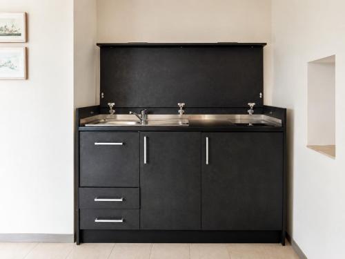 a bathroom with a sink and a black wall at Domo s'Altura in Porto Rotondo