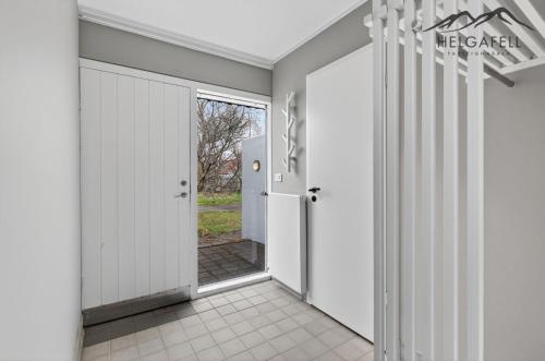 a hallway with white walls and a door to a yard at Kleppjárnsbraut in Kleppjárnsreykir