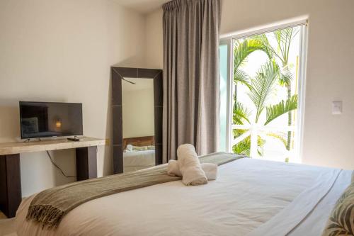 a bedroom with a bed and a large window at Costa Brava Apartments I Ocean Front in Puerto Aventuras