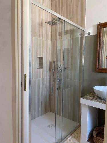 a glass shower in a bathroom with a sink at Assunta Affittacamere in Vitigliano