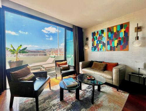 a living room with a couch and a large window at Hôtel Cannes Centre Univers in Cannes